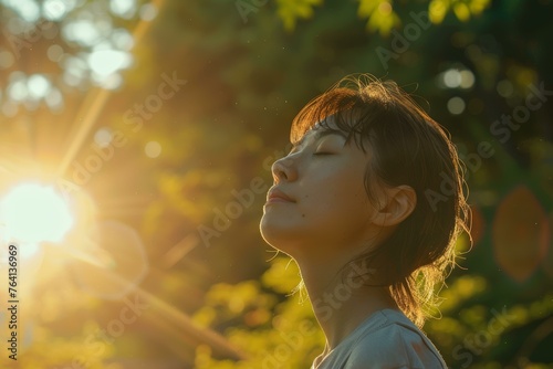 Woman basking in the golden sunlight amidst nature © BrightWhite
