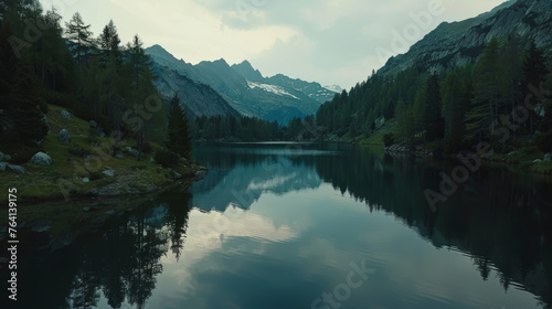 Serene mountain lake reflecting a clear blue sky surrounded by evergreen forest