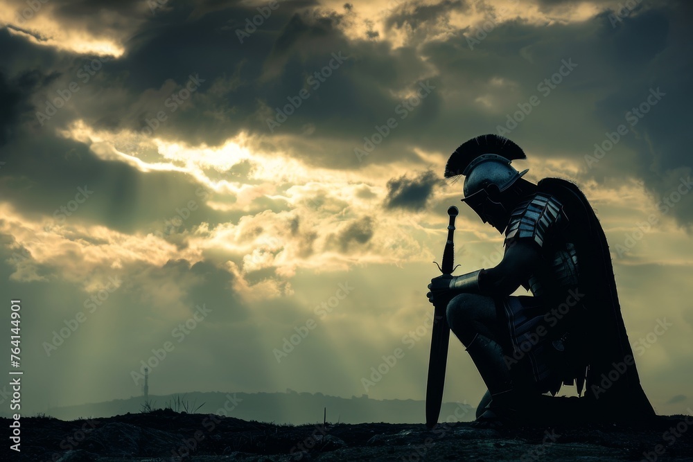 Silhouette of a Roman soldier kneeling and praying before a battle, with a stormy sky overhead. - obrazy, fototapety, plakaty 