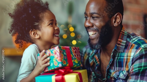 A man and a little girl are standing together, the man holding a gift for the girl. Scene is joyful and festive, as they are celebrating a special occasion photo