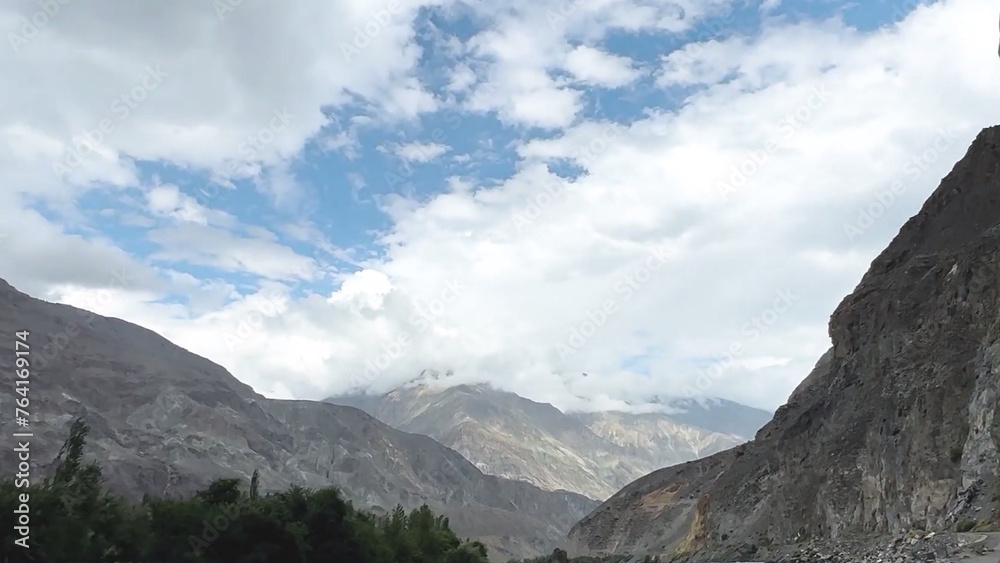 clouds over the mountains Blue sky, mountain peaks, green trees, natural beauty, whiteness of water and snow 