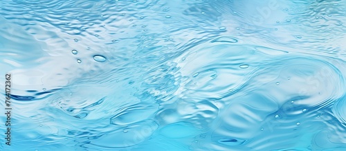 A detailed view of a surface of water in a shade of blue with small bubbles scattered across
