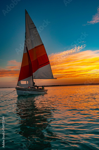 Laguna de Bacalar, barco, atardecer, agua cristalina, cielo naranja, reflejos, horizonte, serenidad, paisaje natural, destino turístico