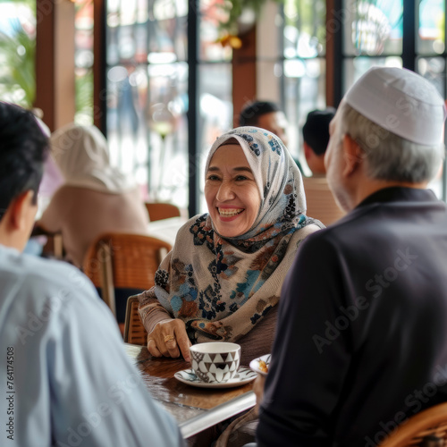 Happy senior woman with male friends at cafe Muslim American.