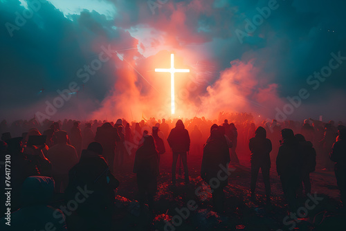 A crowd of people gathered in front of a glowing cross at a religious event. photo