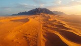 Vehicle trails on sand, desert road, sunset sky
