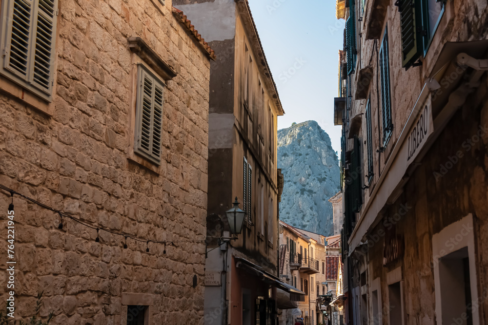 Narrow streets through old town of Omis, Split-Dalmatia, South Croatia, Europe. Mediterranean architecture landmark surrounded by steep Dinara mountains. Travel destination in the Balkans in summer