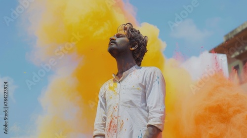 Indian young man in wite dress playing with the color in holi festival photo
