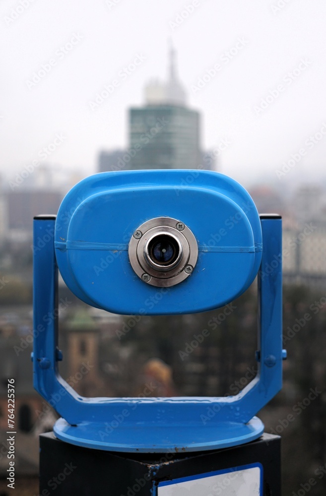 blue monocular aimed at a high-rise building