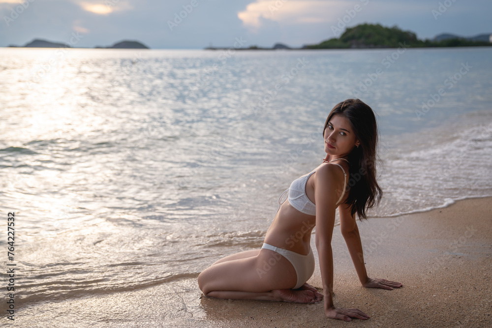A woman is sitting on the beach, enjoying the ocean view. A woman is sitting on the beach, enjoying the ocean view.