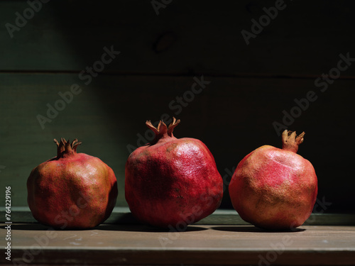 Red organic grown pomegranates in bright sunlight with copyspace. Natural fruit concept image.