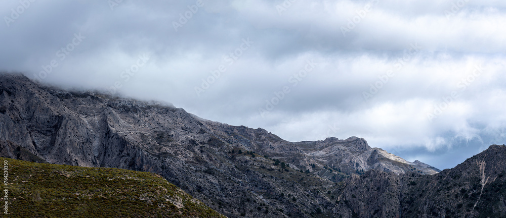 Fog and clouds on hiking trail to Maroma peak in thunderstorm day, Sierra Tejeda, Spain 