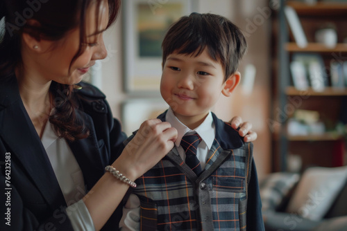 A mother is helping a her son arrange the collar  back to school and parenting concept.