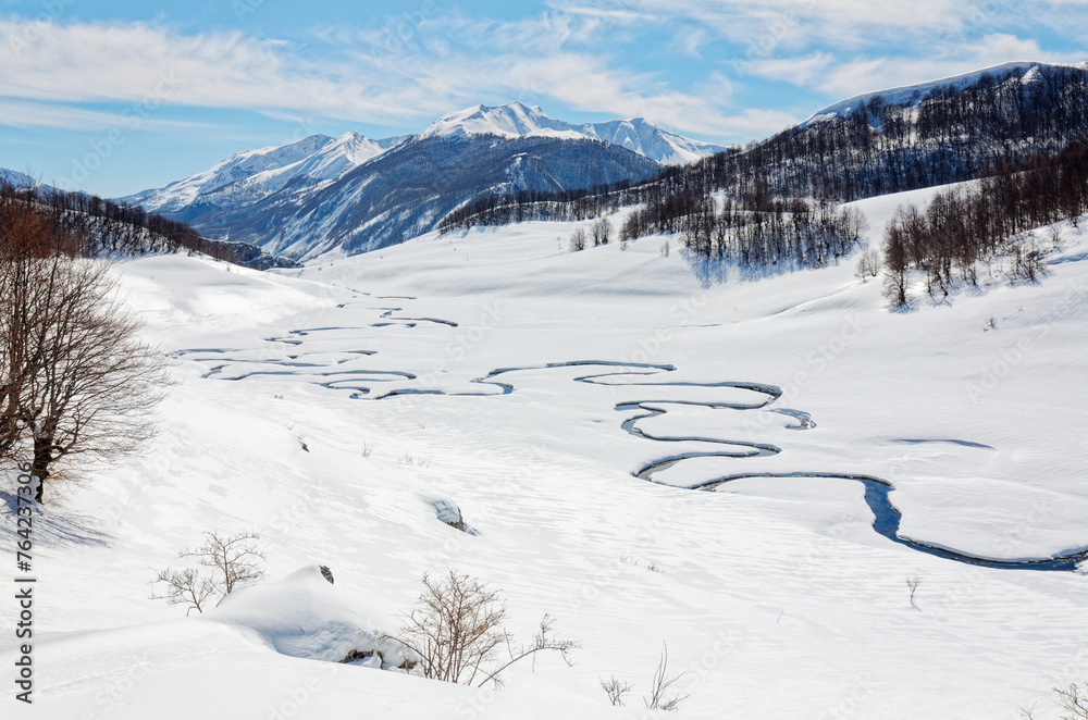 Winter scenery of the Studeni Potok meandering stream located near the village of Umoljani, on the southern side of Bjelašnica, Bosnia and Herzegovina. Beautiful landscapes and rural tourism.