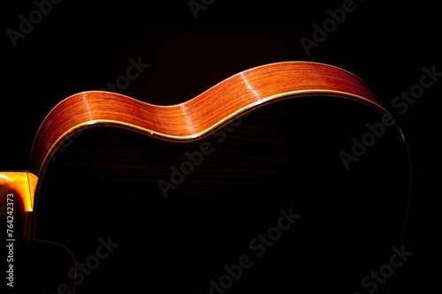 Classical Spanish flamenco guitar close up, dramatically lit isolated on black background with copy space.