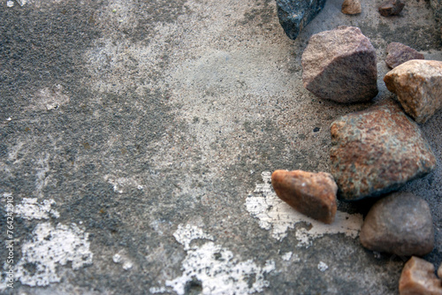 Granite stones lie on a cement screed. Large granite stones lie chaotically, top view. Granite stones next to each other. photo