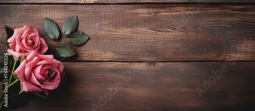 Pink roses on a wooden table with a green leaf