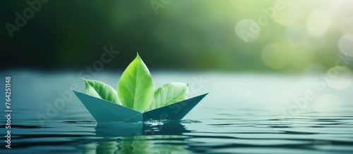 A paper boat floating on water with green leaves as a clean energy concept photo