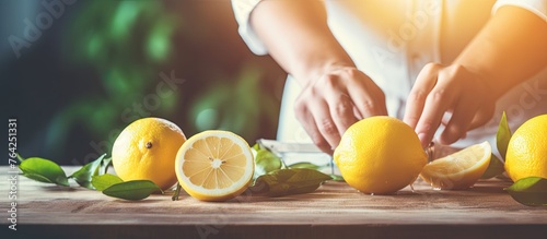 Hands slicing lemon on cutting board with knife