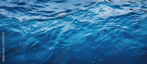 A close-up view of a single wave in the vast expanse of the ocean with clear blue water