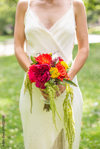 Bride in delicate gown holding autumn wedding bouquet