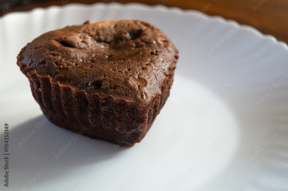 Chocolate cupcake in the shape of a heart on a plate Chocolate cupcake in the shape of a heart on a plate