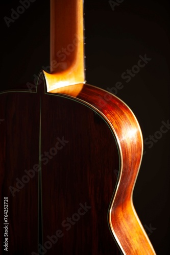 Classical Spanish flamenco guitar close up, dramatically lit isolated on black background with copy space.