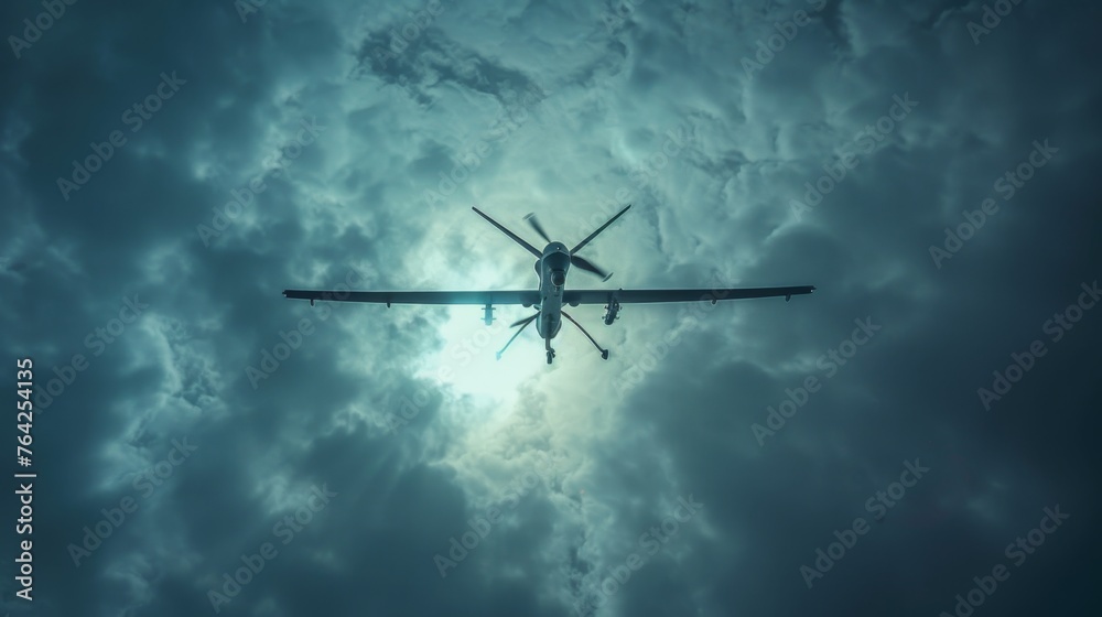 A military unmanned aerial vehicle UAV patrols flying over the clouds - obrazy, fototapety, plakaty 