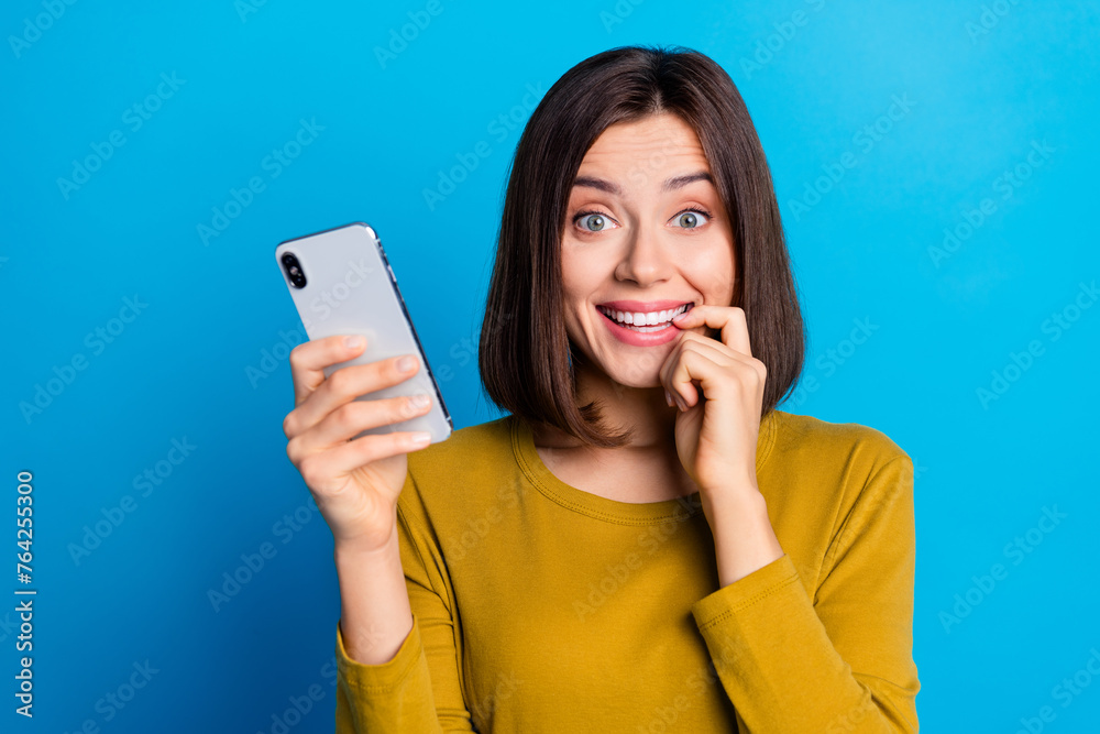 Photo of cunning cute woman wear shirt finger mouth chatting modern gadget empty space isolated blue color background Photo of cunning cute woman wear shirt finger mouth chatting modern gadget empty space isolated blue color background