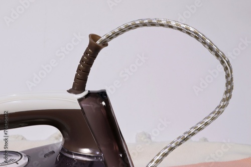 The back of a household iron and electrical cord.
