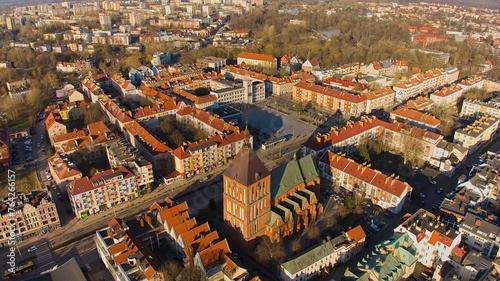 Aerial view of Koszalin city center during the "golden hour" with cathedral, Victory Street, and town hall.