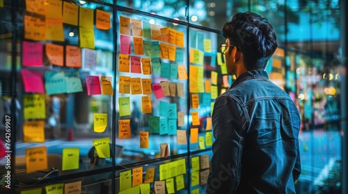 A creative brainstorming session for career rethinking with post-it notes on a glass wall © Татьяна Креминская