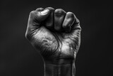 Power and Resistance: A Black and White Image of a Clenched Fist Raised in Strength. This photo symbolizes defiance, strength, and unity against challenges