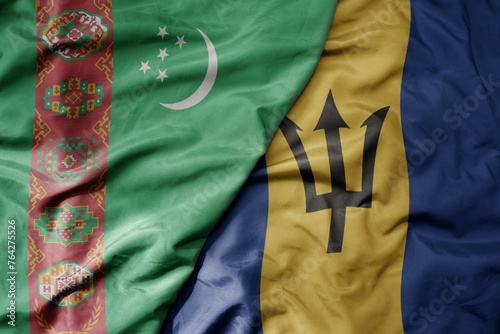 big waving national colorful flag of barbados and national flag of turkmenistan.