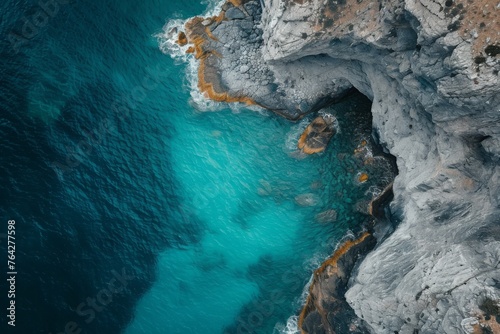 An overhead perspective capturing a large expanse of water and its surrounding landscape, A cinematic shot from above of a turquoise sea and weathered cliffs, AI Generated