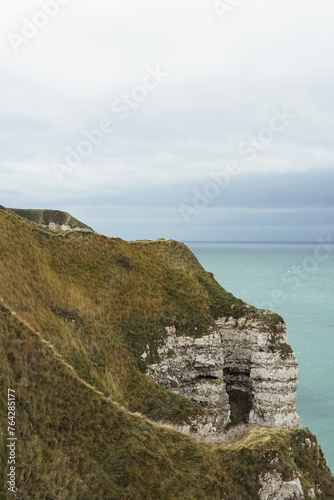 A cliff overlooking the ocean, in France, near Normandy, white rock, green grass, blue sea, high angle view
