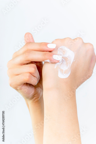 Beautiful Woman Hands. Female Hands Applying Cream, Lotion. Spa and Manicure concept. Female hands with french manicure. Soft skin, skincare concept. Hand Skin Care