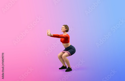 Full body length gaiety shot athletic and sporty young woman with fitness elastic resistance band in squat exercise posture on isolated background. Healthy active and body care lifestyle.