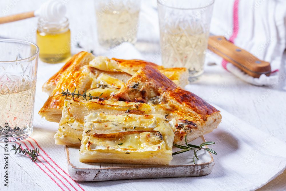 Puff pastry pie with cheese, pears, nuts and honey, served with champagne.