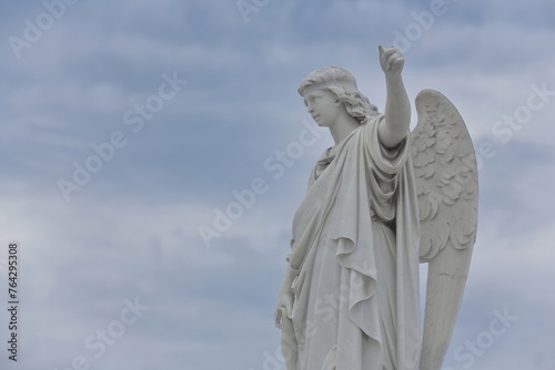 Marble angel with left arm outstretched topping a grave on the Avenida Cristobal Colon Avenue west side-Cementerio de Colon Cemetery. Havana-Cuba-095 photo