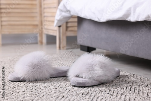 Grey soft slippers on carpet at home