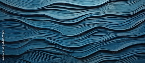 An up-close view of a wall painted in a shade of blue with wavy and flowing patterns resembling waves