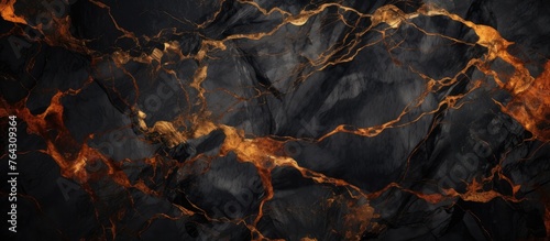 A detailed view capturing the intricate patterns of a black marble slab featuring striking orange streaks