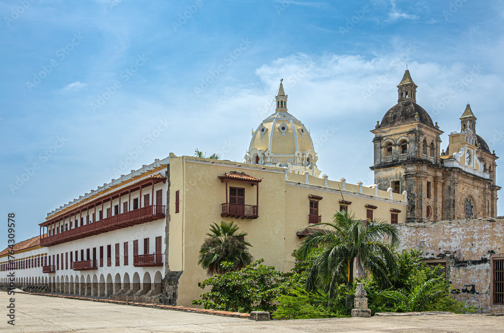 Cartagena, Colombia - July 25, 2023: Closeup, Santuario de San Pedro Claver church towers, historic front facade seen from Baluarte de San Ignacio bastion under blue cloudscape