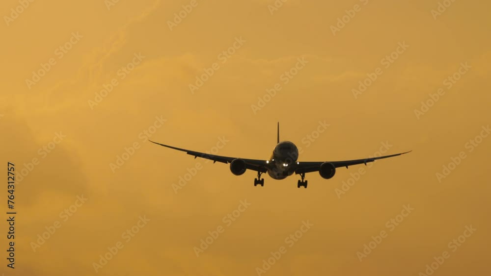 Jet airplane approaching to land in the sunset sky, long shot. Tourism and travel concept Jet airplane approaching to land in the sunset sky, long shot. Tourism and travel concept