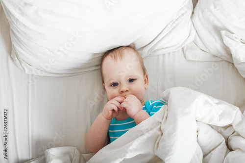 Baby 11 months old on the bed getting ready to sleep.