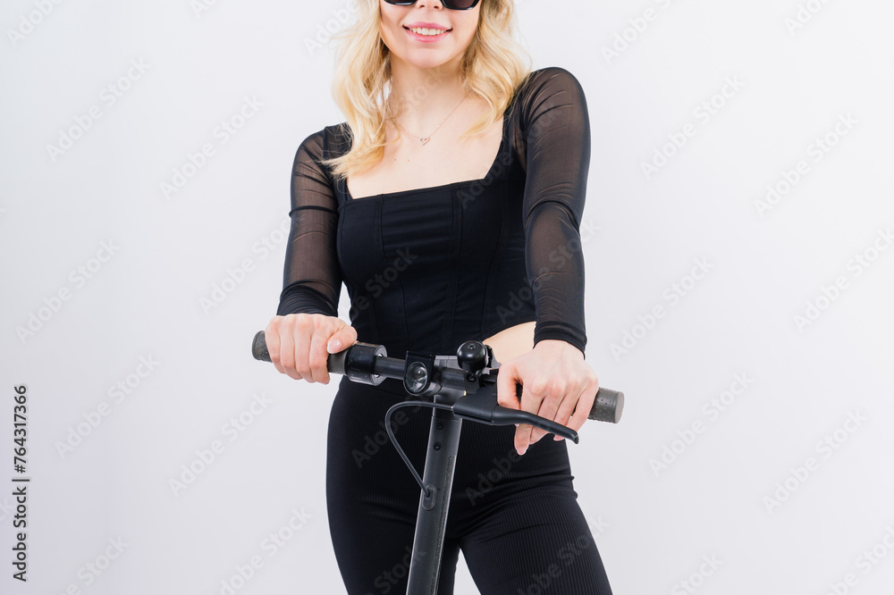 Blonde woman on red white background sitting on electro scooter and resting, copy space Blonde woman on red white background sitting on electro scooter and resting, copy space