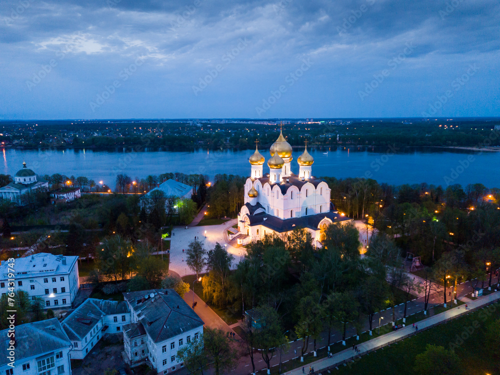 Scenic view from drone of medieval Yaroslavl Orthodox Assumption cathedral on background with Volga River and cityscape at night, Russia..