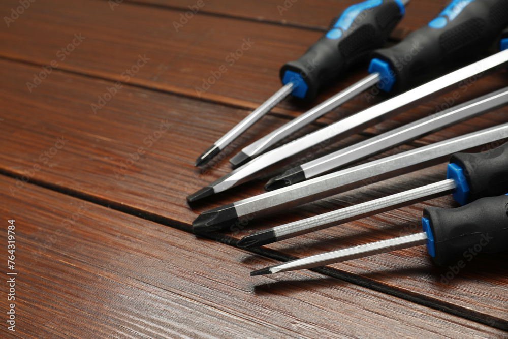 Set of screwdrivers on wooden table, closeup. Space for text Set of screwdrivers on wooden table, closeup. Space for text
