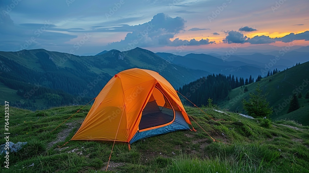 Portrait of an orange tent in the mountains under a beautiful sky